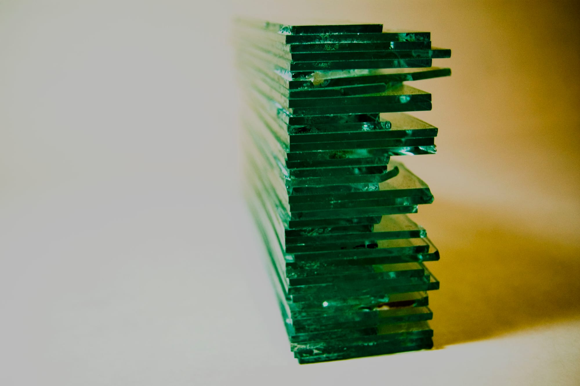 An additional view of the stacked sheets of glass showing variations in length of another edge.