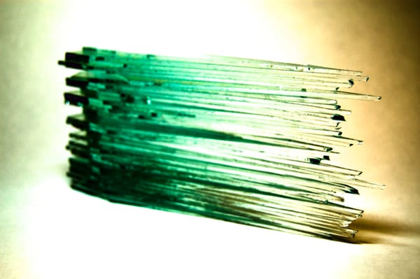 Stacked sheets of glass with it's edges cut to specific lengths to represent data values.